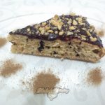 Фото 1. Отрезанный кусочек бисквита с кусочками шоколада.